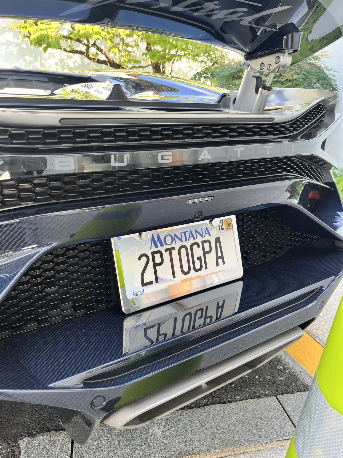 The front of a Bugatti, its Montana plate reading 2PTOGPA in a carbon fiber bumper.